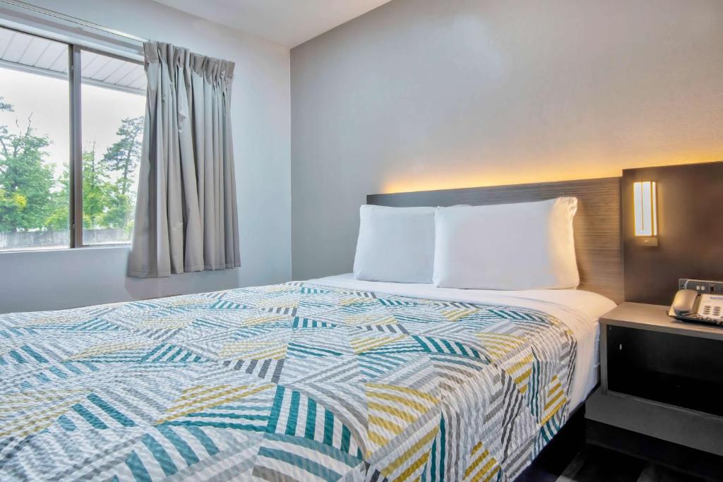 a hotel room with a bed and a window at Motel 6 Texarkana, TX in Texarkana