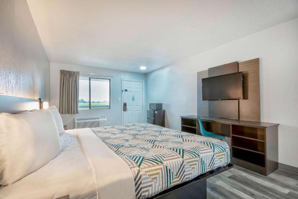 a hotel room with a bed and a television at Motel 6 Texarkana, TX in Texarkana