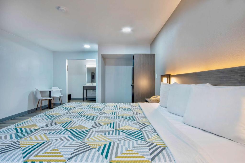 a bedroom with a large bed with a colorful bedspread at Motel 6 Texarkana, TX in Texarkana