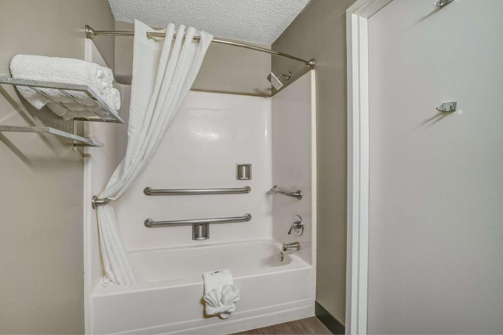 a bathroom with a bath tub with a shower curtain at Motel 6 Texarkana, TX in Texarkana