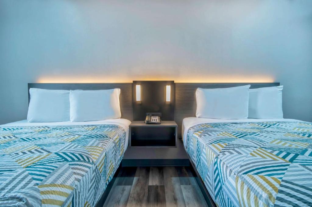 two beds sitting next to each other in a room at Motel 6 Texarkana, TX in Texarkana