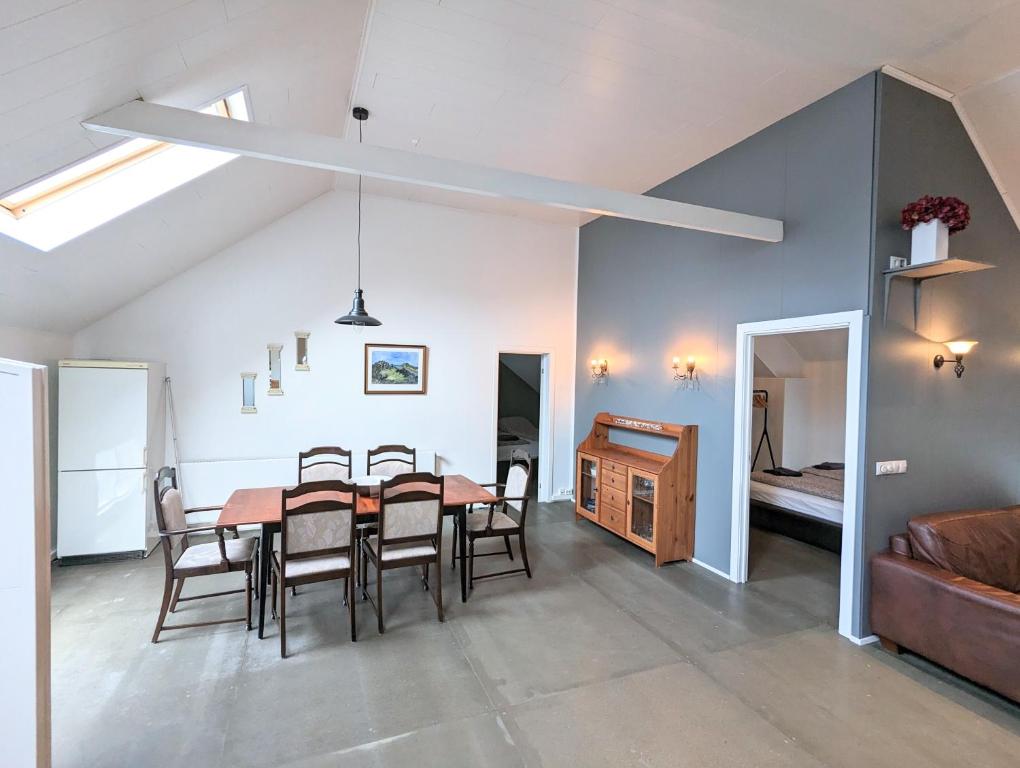 a dining room and living room with a table and chairs at Central Apartments in Vestmannaeyjar