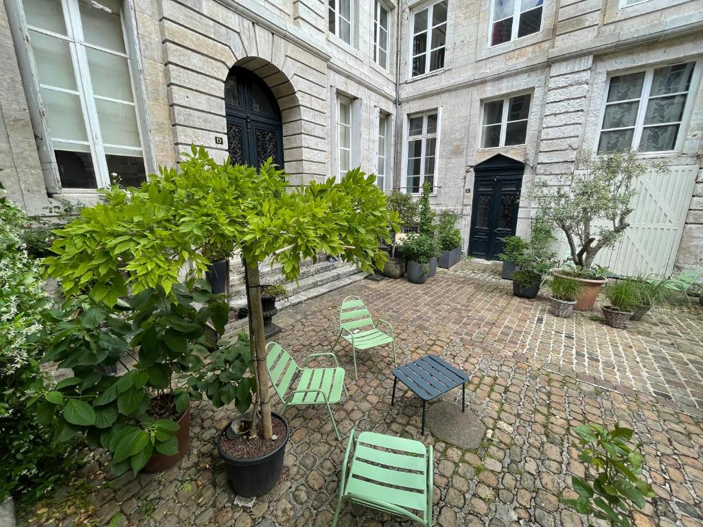 a courtyard with chairs and a table and trees at Le villequier 8 Rouen centre in Rouen