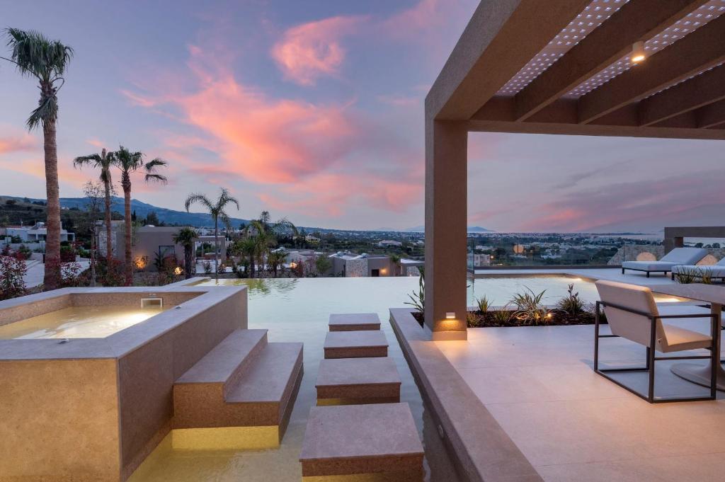 - une terrasse avec un bain à remous au-dessus d'un bâtiment dans l'établissement Maravilla Luxury Living, à Kos