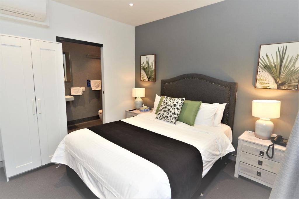 1 dormitorio con 1 cama grande y 2 lámparas en Mariners Court Hotel Sydney, en Sídney