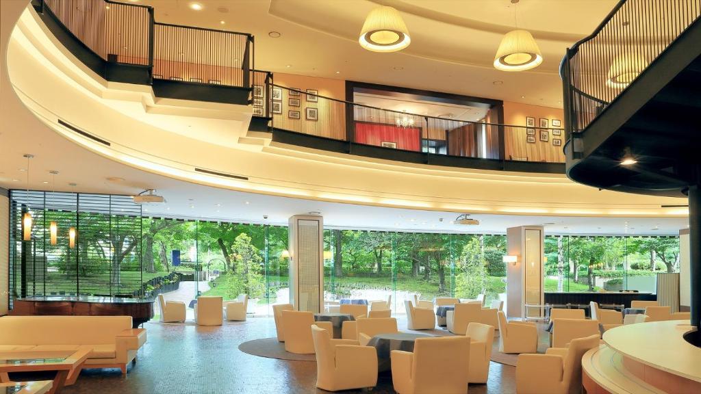 a lobby with white chairs and tables in a building at Premier Hotel Nakajima Park Sapporo in Sapporo