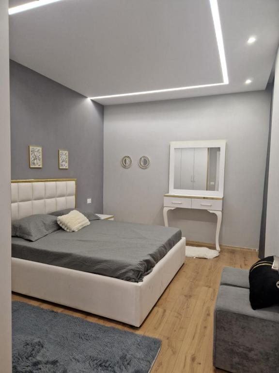 ein Schlafzimmer mit einem großen Bett und einem Schreibtisch in der Unterkunft Deluxe Rent Apartment in Tirana