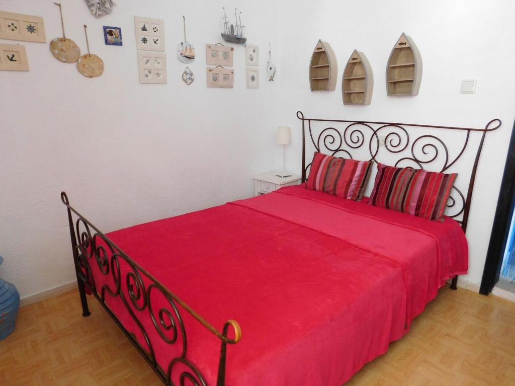 a bedroom with a red bed with a red bedspread at Apartments with a parking space Povlja, Brac - 21089 in Povlja