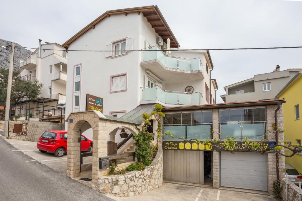 een gebouw met een garage ervoor bij Apartments and rooms by the sea Nemira, Omis - 2781 in Omiš
