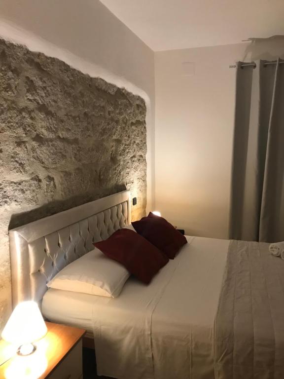 una camera con un letto bianco con due cuscini rossi di Monis Hogar a Arzachena
