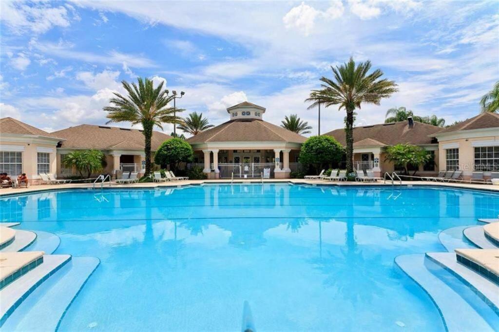 a large swimming pool with palm trees and houses at Pool Home in Famous Windsor Palms Resort 4 Miles to Disney, Free Resort Amenities in Kissimmee