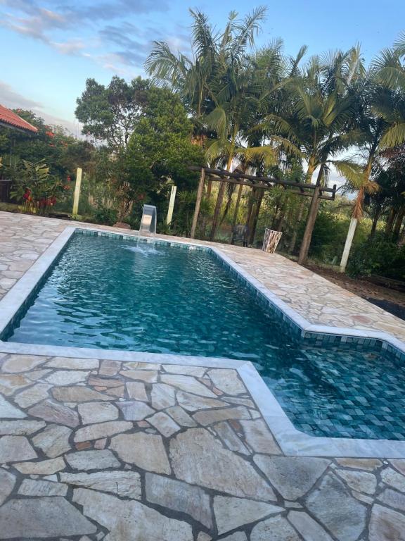 uma piscina com um piso de pedra e uma piscina de hidromassagem em Pousada Rural Ouro Verde em Eldorado