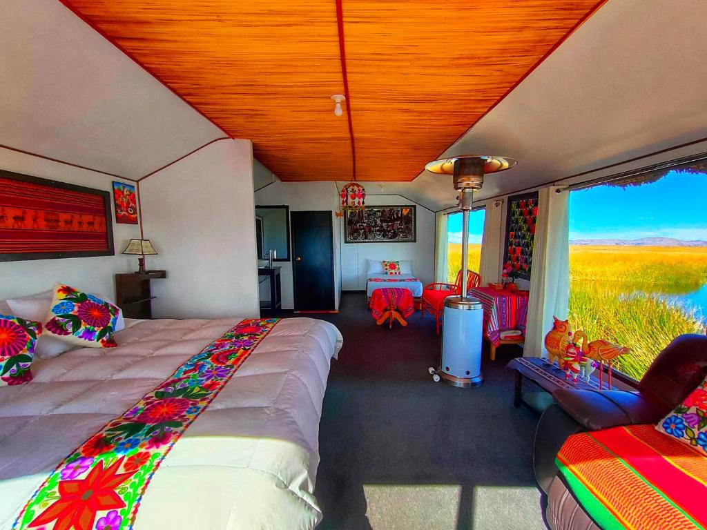 um quarto com uma cama, uma mesa e cadeiras em Titicaca Origins Perú em Puno