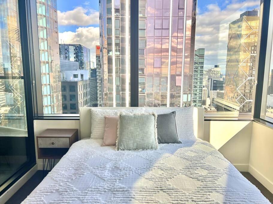 メルボルンにあるStunning 2-Bed Apartment with Panoramic CBD Viewsの大きな窓のある部屋のベッド