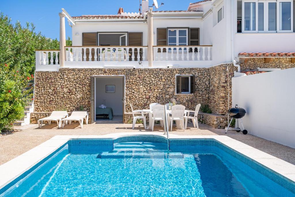 una villa con piscina di fronte a una casa di Can Poriol ad Alaior