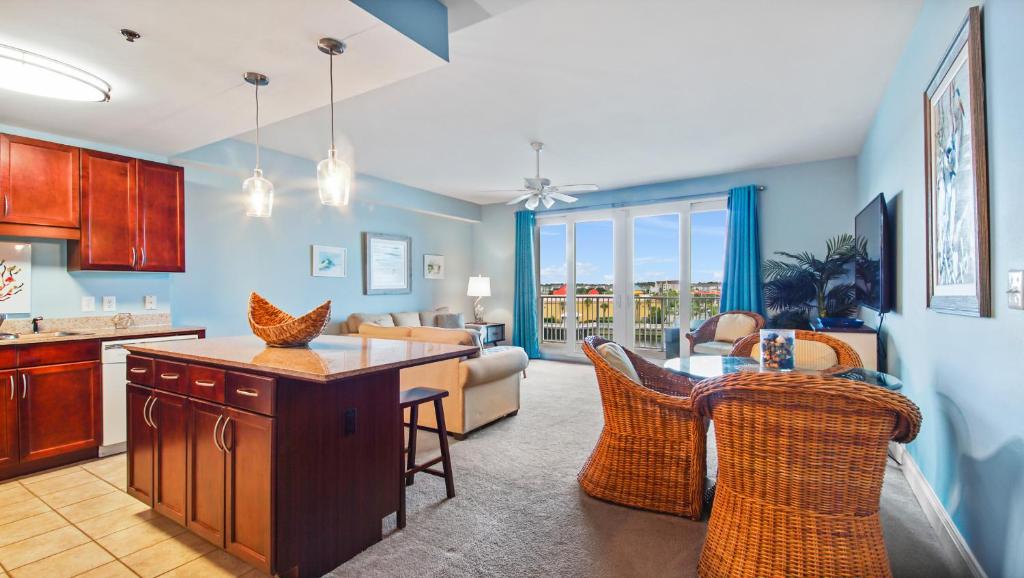 a kitchen and living room with a table and chairs at Laketown Wharf #317 by Nautical Properties in Panama City Beach