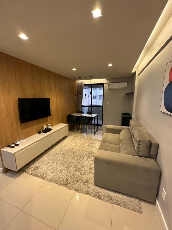 a living room with a couch and a flat screen tv at Flat Number One - Ponta D'areia - Ferreira Hospedagens in São Luís