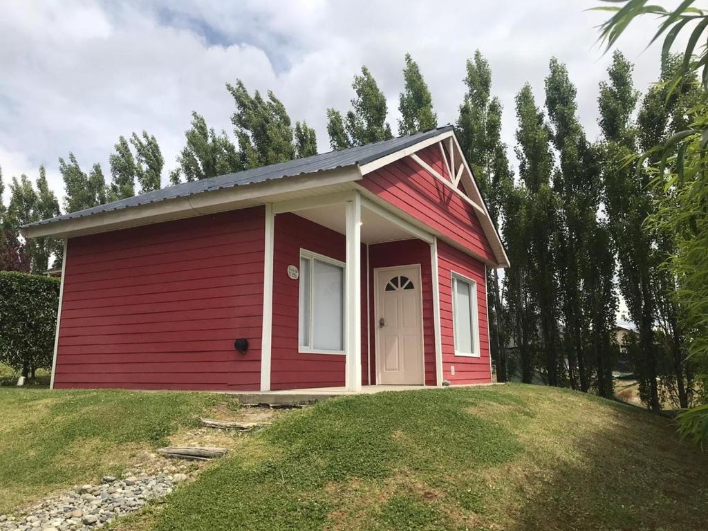 a red tiny house on a grassy hill at Casa Roja in El Calafate