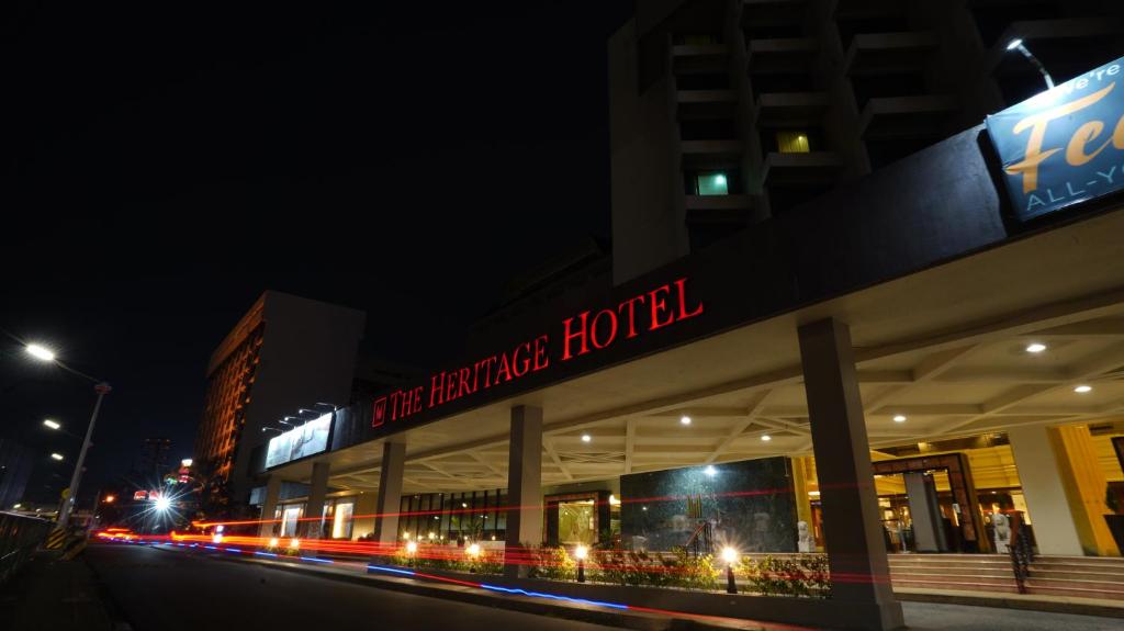 a building with a sign that reads performance hotel at night at The Heritage Hotel Manila in Manila