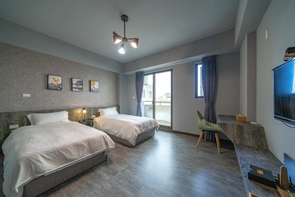 台南市にあるPark Oasis Tainan Villaのベッドルーム1室(ベッド2台、薄型テレビ付)