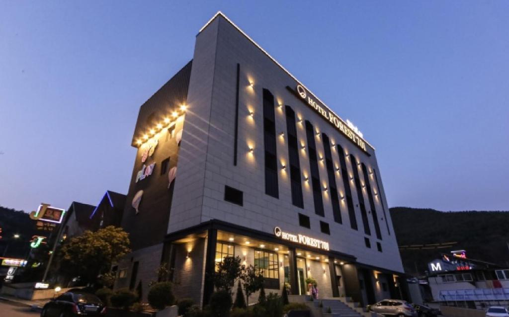ein großes Gebäude mit seitlicher Beleuchtung in der Unterkunft Forest 701 hotel in Changwon