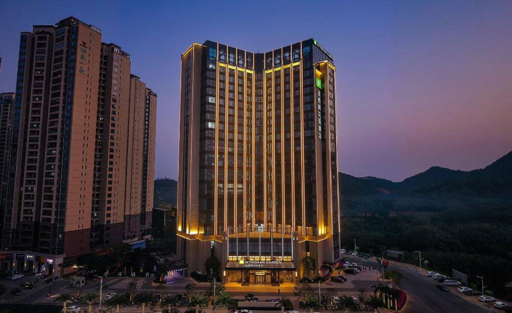 un grand bâtiment avec des lumières sur lui dans une ville dans l'établissement Wyndham Garden Gaozhou, à Gaozhou