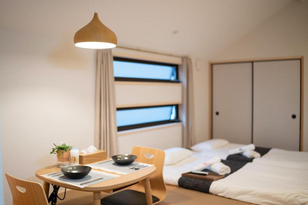 Cette petite chambre comprend une table et un lit. dans l'établissement HANASTAY花渓居 · 梨（NASHI), à Osaka