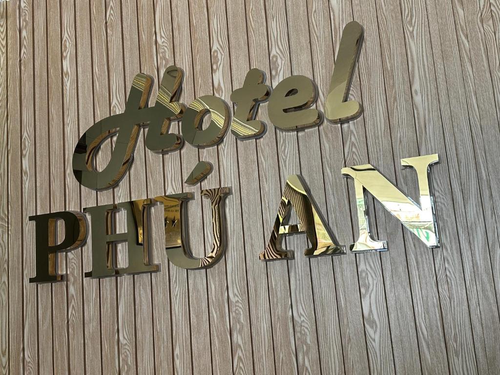 a sign for a pizza place on a wooden wall at Phú An Hotel in Ho Chi Minh City