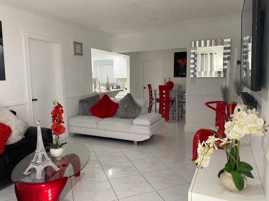 - un salon avec un canapé blanc et des fauteuils rouges dans l'établissement Beautiful House 7 min from Miami Airport w FREE parking, à Miami