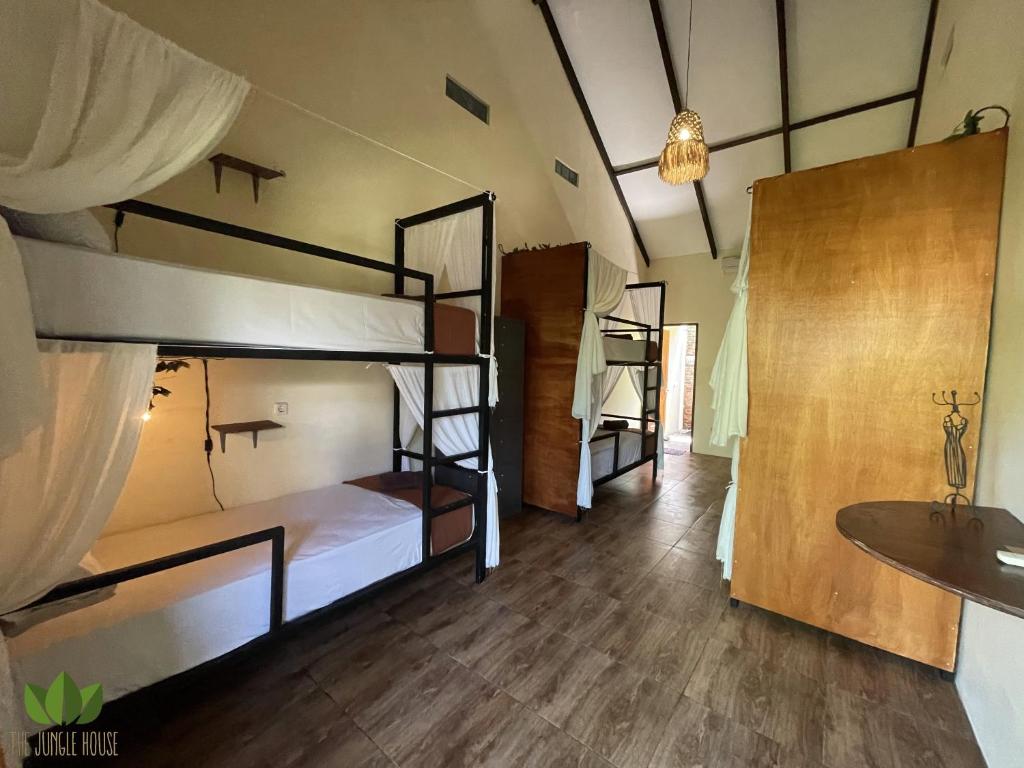 um quarto com 3 beliches e um lavatório em The Jungle House em Canggu