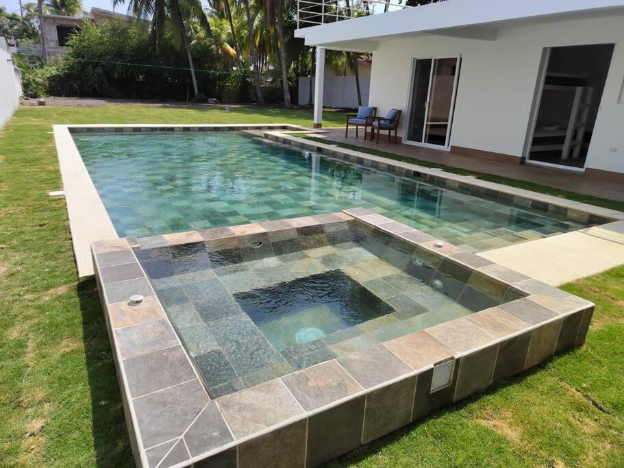 a swimming pool in the yard of a house at Hermosa Casa de Playa in Escuintla