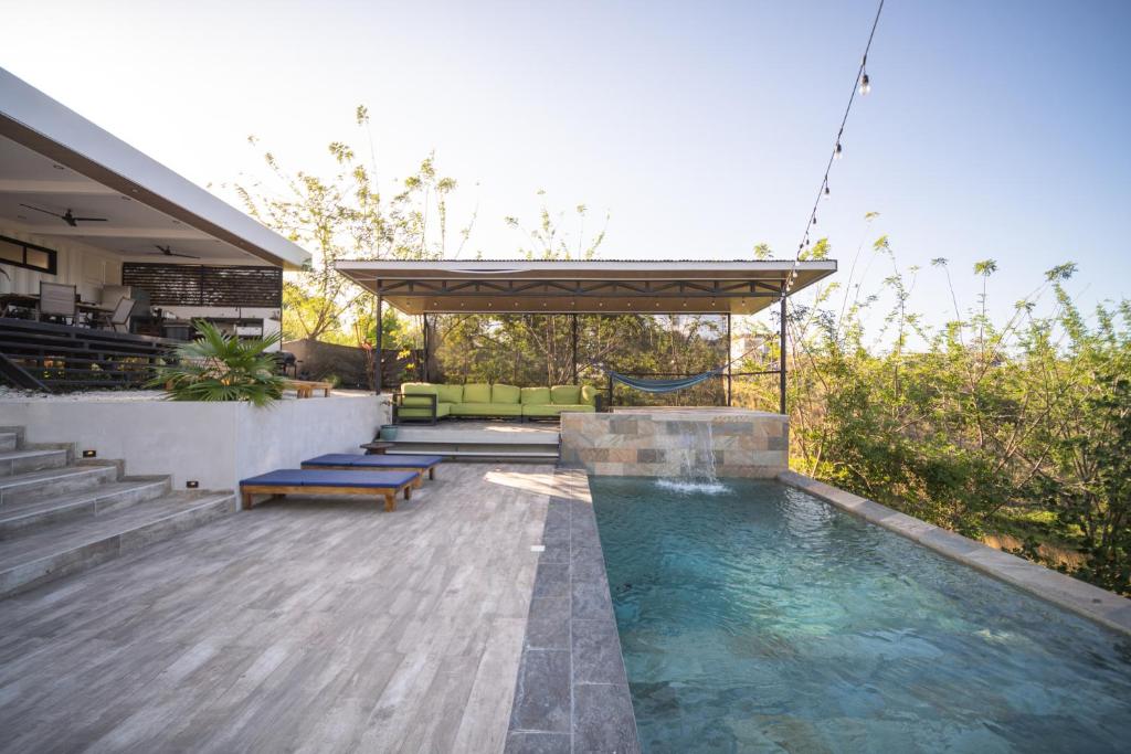 a swimming pool with benches and a pavilion at Vista Loma Estate in San Isidro