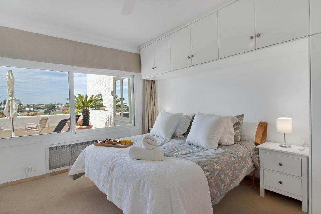 sypialnia z łóżkiem i dużym oknem w obiekcie Lujoso apartamento con alucinantes vistas al golf - Iwii A 38 w Marbelli