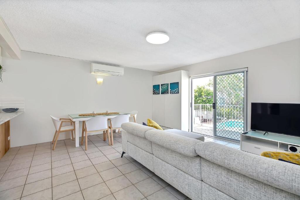 a living room with a couch and a television at Beachcomber Unit 4 7 Dingle Ave in Caloundra