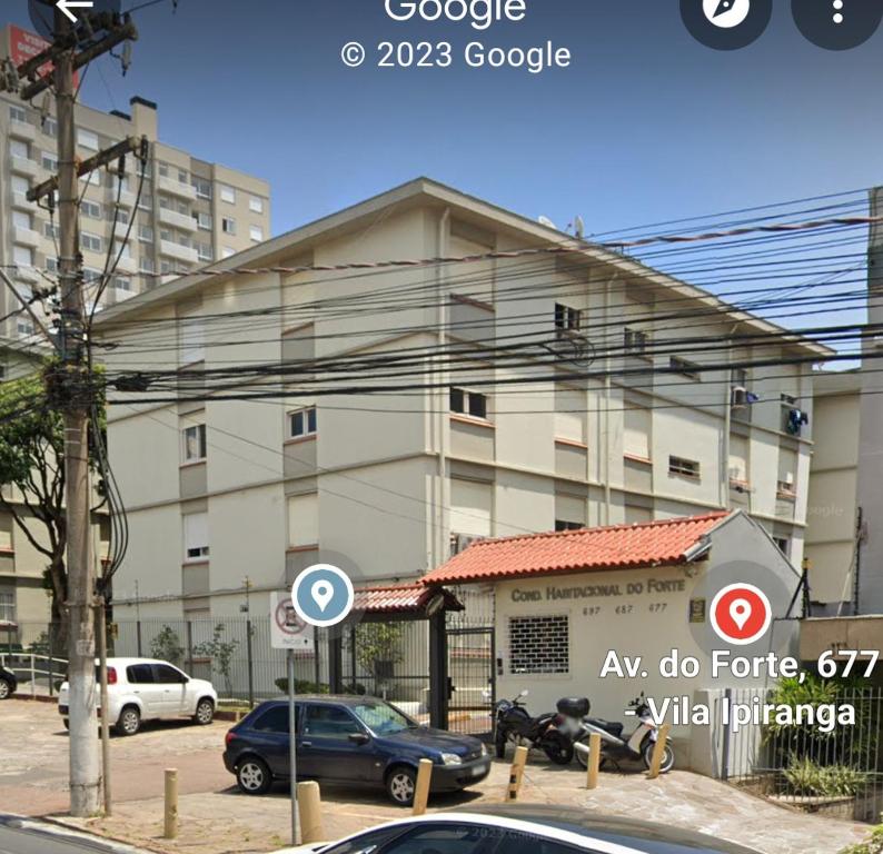a building with cars parked in front of it at Amplo apt próximo ao Consulado in Porto Alegre