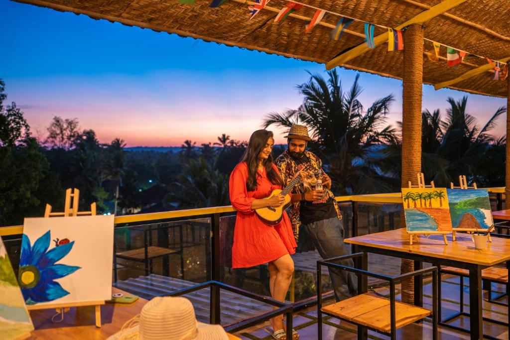 a man and a woman standing on a balcony at The Hosteller Goa, Arpora in Arpora