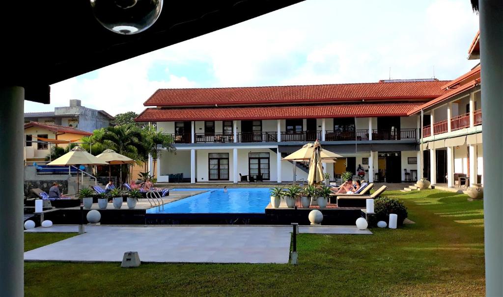 a resort with a swimming pool in front of a building at IMAGINE Villa Hotel in Mirissa