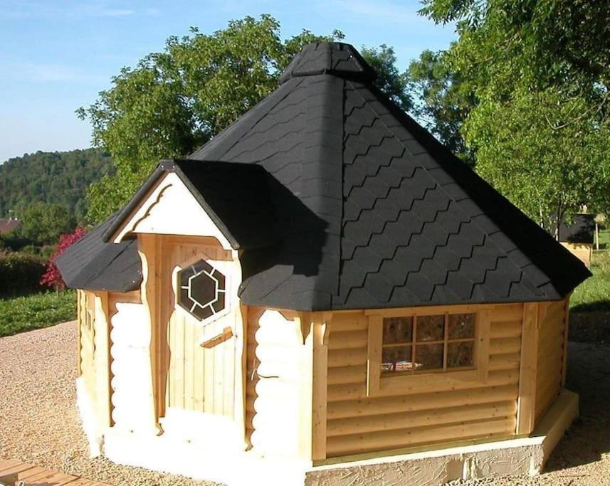 une grande cabane en bois avec un toit noir dans l'établissement Kota Finlandais Vacances Insolites, à Véria