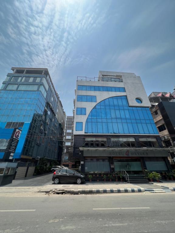 un coche aparcado delante de dos edificios altos en Hotel O2 Oxygen en Calcuta
