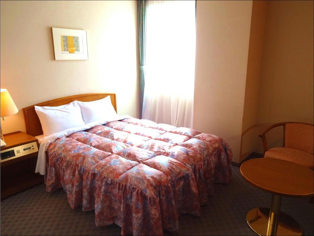 Postel nebo postele na pokoji v ubytování Shingu UI Hotel