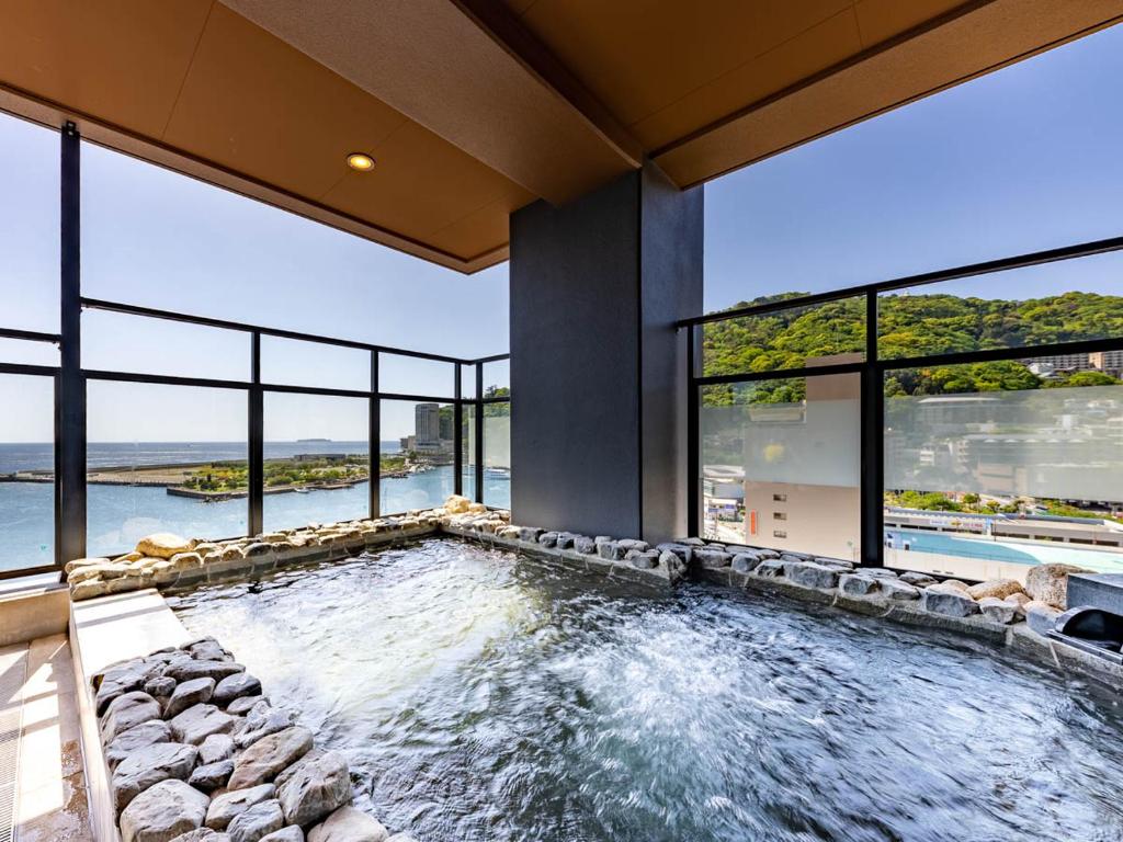 an indoor pool with a view of the water in a house at LiVEMAX RESORT Atami OCEAN in Atami