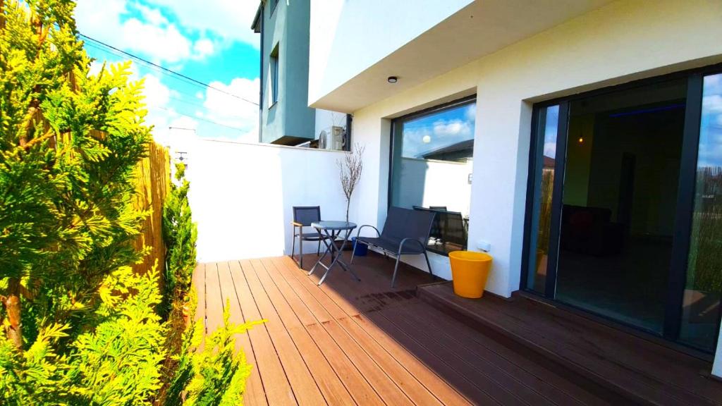 - un balcon d'une maison avec une terrasse en bois dans l'établissement Mogosoaia High Living Apartment, à Chitila