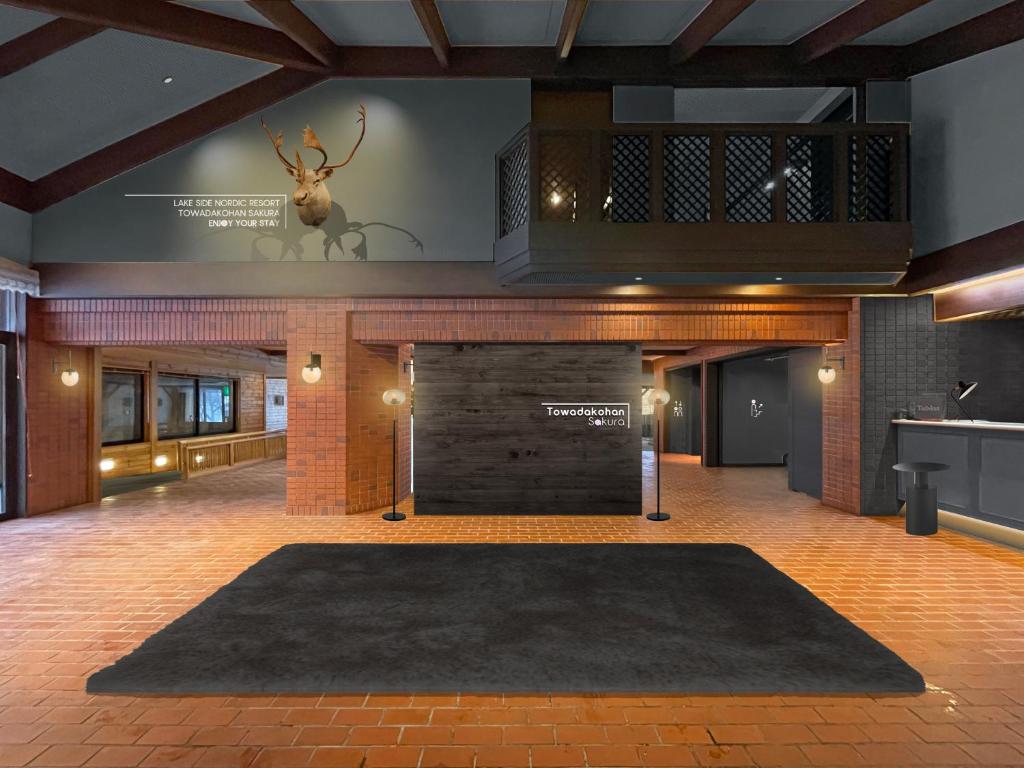 a lobby with a fireplace and a deer head on the wall at Towadakohan Sakura in Towada