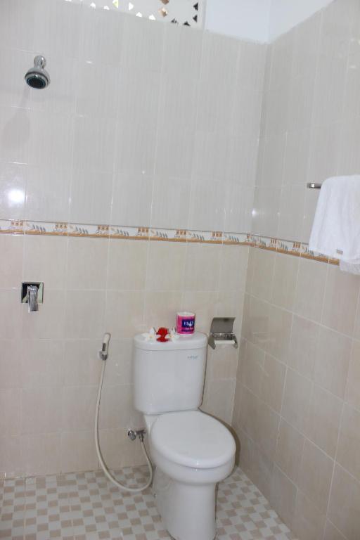 a bathroom with a white toilet in a room at Sudiana House in Ubud