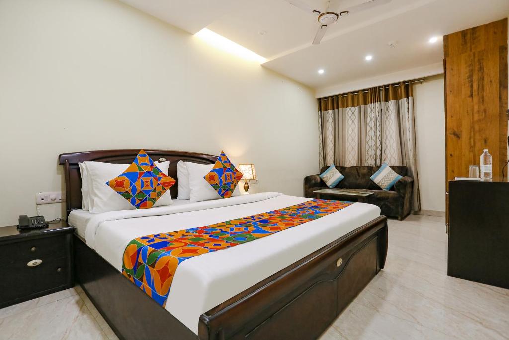 a bedroom with a large bed and a couch at FabHotel F9 NSP in New Delhi
