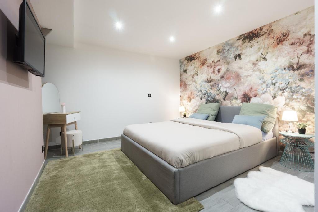 a bedroom with a bed and a painting on the wall at Romance O'Berry in Châteauroux