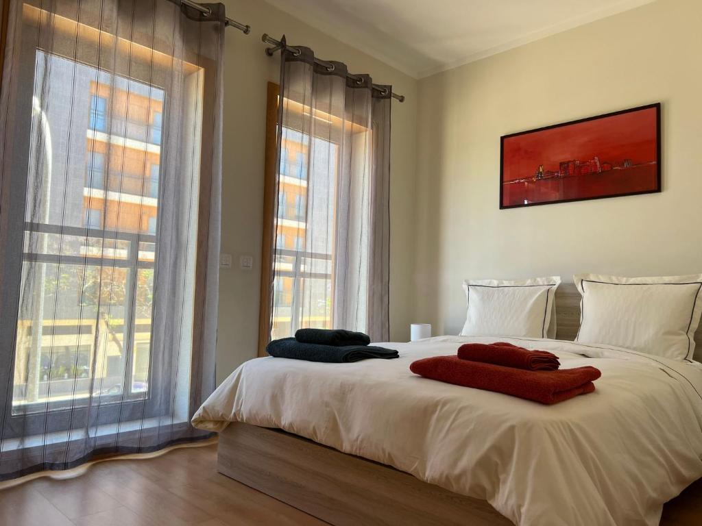 een slaapkamer met een bed met twee handdoeken erop bij Olhão Marina Village in Olhão