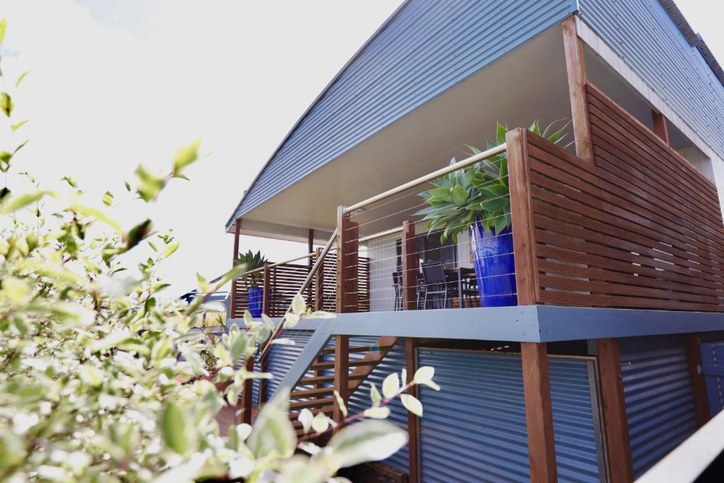 a house with a balcony with a plant on it at Two Rivers - Harriet in Kingscote