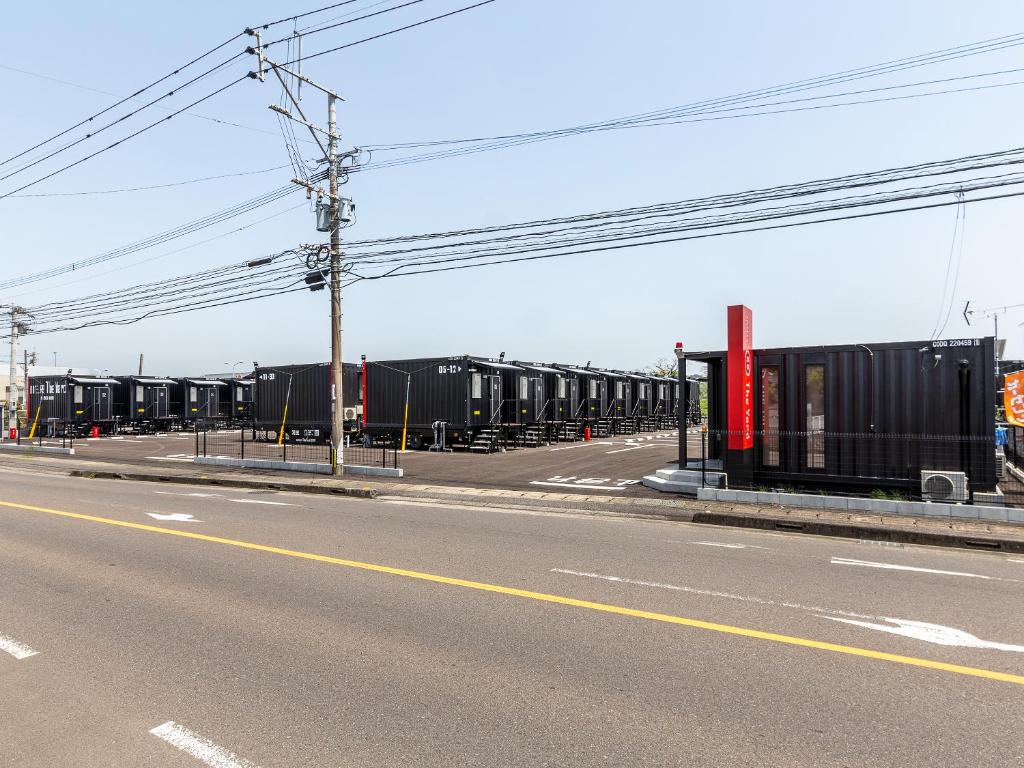 an empty street with a bunch of containers on the side of the road at HOTEL R9 The Yard Saito in Saito