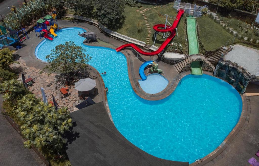 an overhead view of a pool at a water park at Umadhatu Resort by Amerta in Tabanan